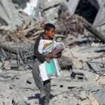 Seorang siswa Palestina di Jalur Gaza mengais buku dari sekolah yang hancur