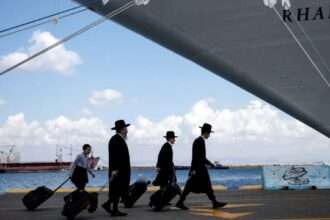 Orang-orang Yahudi Israel membawa barang-barang mereka di Haifa ke sebuah kapal menuju Siprus. (Oleh Reuters)