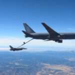 Pesawat Boeing KC-46 Pegasus sedang mengisi ulang bahan bakar sebuah jet tempur F-16 di udara.