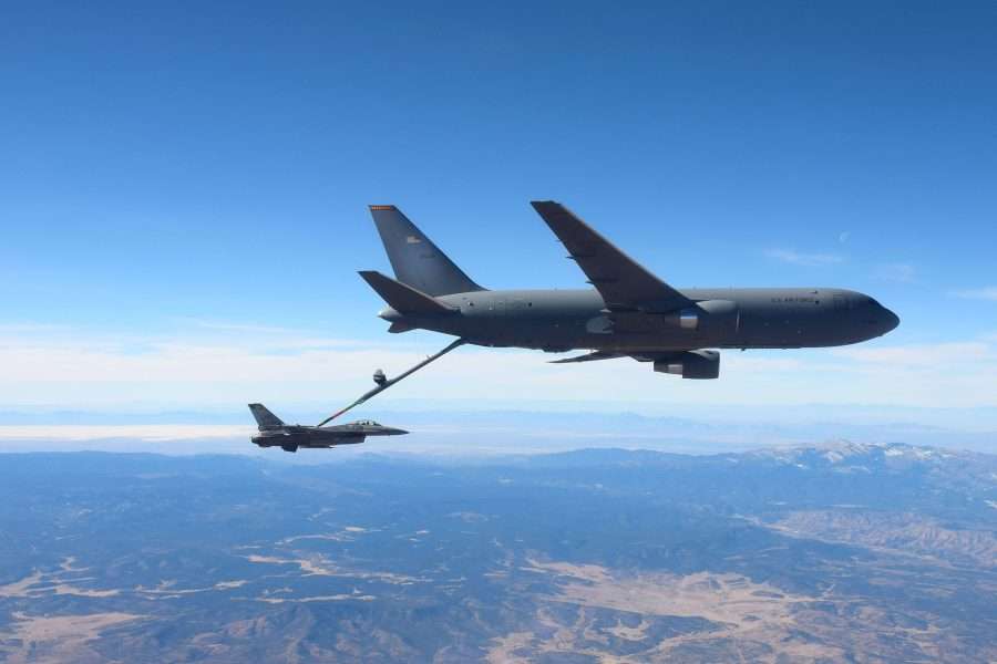 Pesawat Boeing KC-46 Pegasus sedang mengisi ulang bahan bakar sebuah jet tempur F-16 di udara.